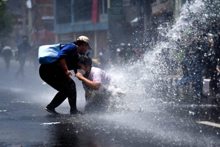 Police use water canons and baton at protest against government’s handling the pandemic
